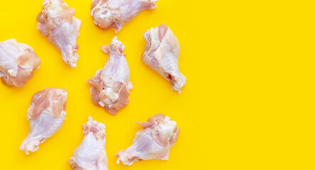 Fresh raw chicken wings (wingstick) on yellow background.