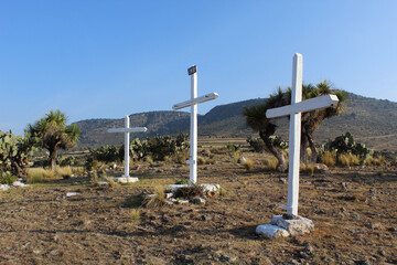 Tres cruces pintadas de color blanco, usadas para la representación del viacrucis en un poblado de Hidalgo, México.  