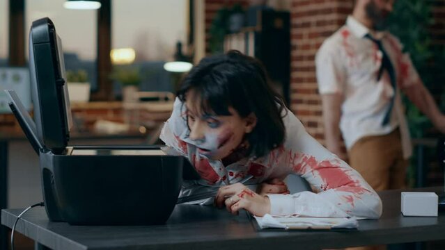 Dumb creepy looking zombie trying to use photocopy machine. Spooky evil brainless monster with deep and bloody scars and wounds while damaging scanner machine in company office workspace.