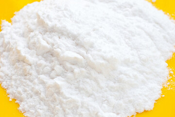 Baking soda on yellow background.