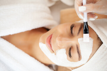 Beautiful woman with facial mask at beauty salon