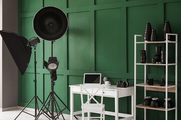 Interior of modern office with photographer's workplace, shelving unit and equipment