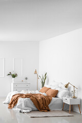 Interior of light cozy bedroom with chest of drawers