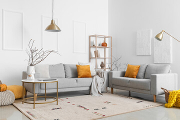 Interior of light living room with grey sofas and shelving unit
