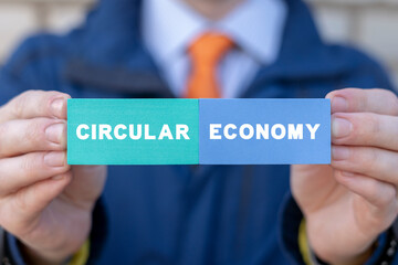 Businessman holding styrofoam colorful blocks with inscription: CIRCULAR ECONOMY. Concept of circular economy.