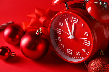 New Year clock and decorations on red background, closeup
