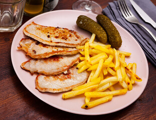 Juicy pork tenderloin with potatoes and salted cucumbers. Slavic cuisine