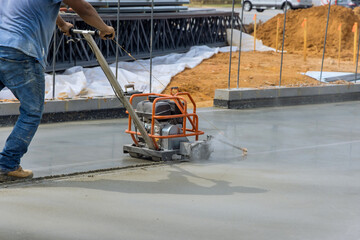 Worker using cutting machine are cutting concrete for expansion isolation joint of foundation...