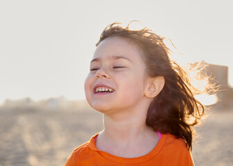 young girl playing on the beach on a warm day in may