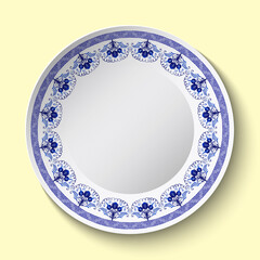 White porcelain or pottery plate with blue floral ornament. Stylized ethnic cobalt painting on porcelain