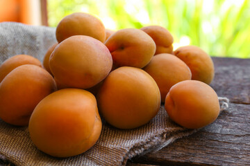 Delicious ripe apricots with napkin on wooden table, closeup