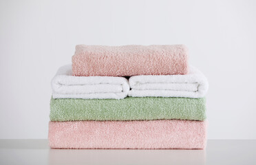 Soft color folded towels on white table