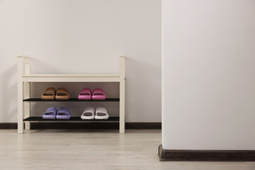 Storage bench with pairs of rubber slippers indoors