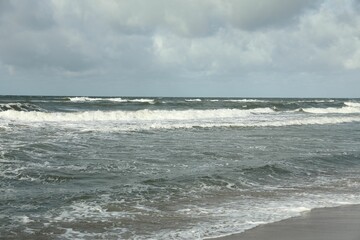 Fototapeta na wymiar Picturesque view of wavy sea on cloudy day