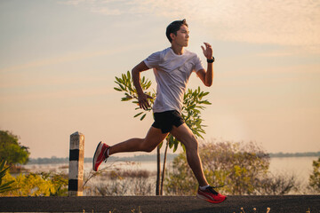 Young man running in the city. Healthy lifestyle concept. Young fitness man runner athlete running at park.