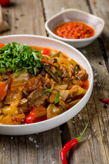 Lagman asian soup with beef and noodles on old wooden table macro close up vertical