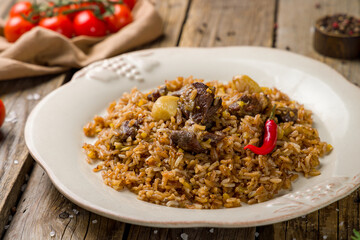 pilaf with beef on old wooden table macro close up