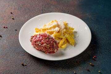 Tartare from beef with french fries on dark stone table