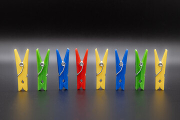 Set of clothespins in different colors with black background
