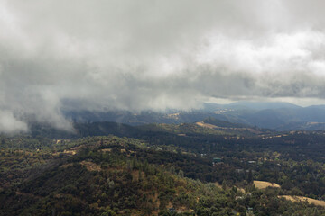 low storm clouds over forested hills