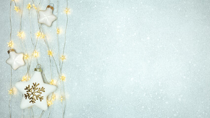 white christmas stars with glowing lights garland on festive silver background. flat lay, top view.