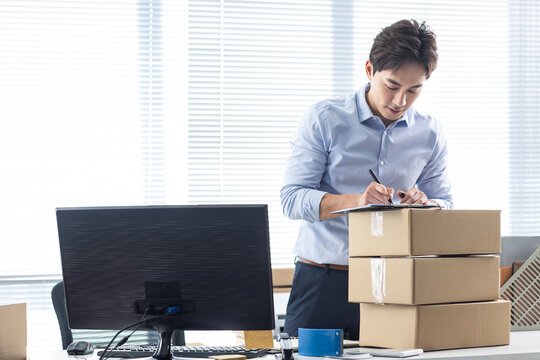 Small business owner packing boxes in office