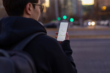 A man checking stock market data on smartphone