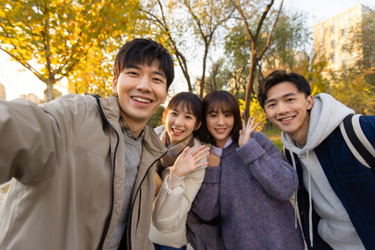 Happy college students taking selfie on campus