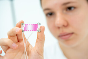 microbiology university girl student holding Lab on Chip microfluidic Devices