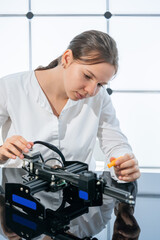 Young woman student assembling electronic devices in the robotics laboratory