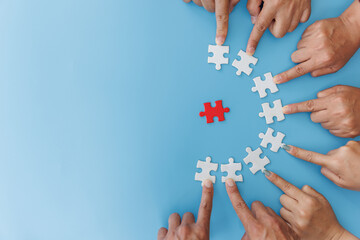 Closeup of businesspeople holding jigsaw puzzle on a blue background. Hand holding the puzzles for...