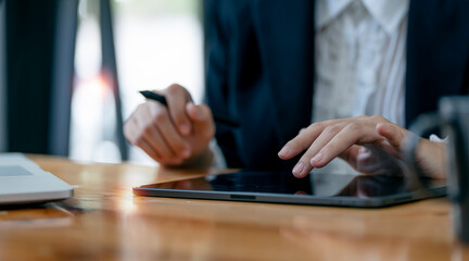 Fototapeta na wymiar Closeup businesswoman hands using digital tablet, sitting at her desk office.