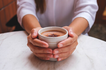Closeup image of hands holding a cup of hot chocolate