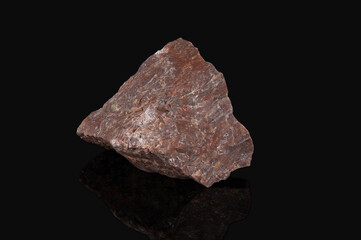 An unprocessed fragment of the mineral rhyolite breccia. Dark red stone with white veins