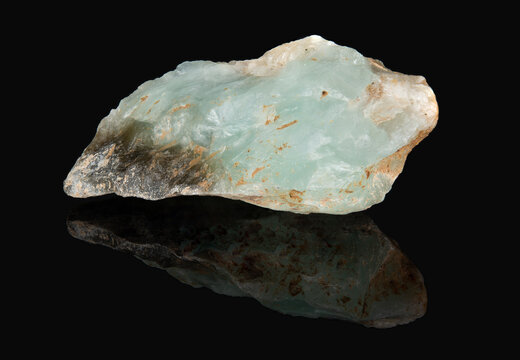 A raw shard of the mineral prehnite. A translucent greenish stone
