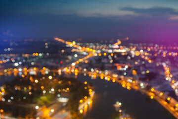 Blurred lights from peak Roi Et Tower, Thailand. Blurry view of city traffic lights and car at night. Night bokeh light in big city, abstract blur defocused background. Vintage or retro color tone.