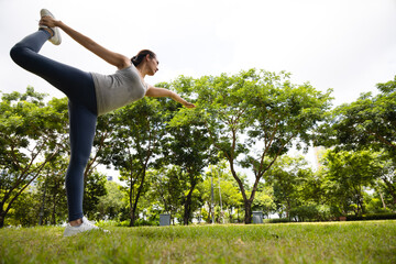 Fototapeta na wymiar Asian woman make yoga posture in park. Concept for healthy lifestyle and oudoor life.