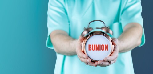 Bunion (hallux valgus). Doctor holds ringing alarm clock with medical term on it.