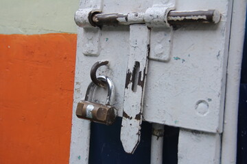 The locked padlock on the iron door is gray. Great for backgrounds