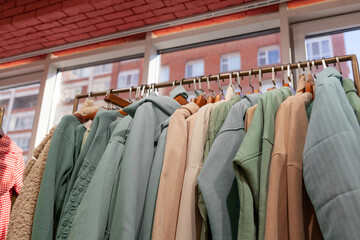 Colorful women's dresses, jackets, trousers and other clothes on hangers in a retail store. The concept of fashion and shopping. Women's clothing boutique.