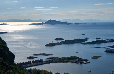 Sunrise above Vestfjorden seen from hiking trail to mount Floya, with the western part of the mainland Norway wall visible at background. Rorbu of Svolvaer at foreground. 