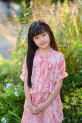 Portrait of a beautiful Asian girl 9 years old with long hair in garden