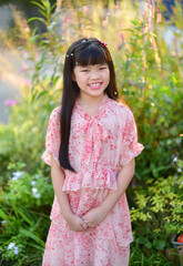 Portrait of a beautiful Asian girl 9 years old with long hair in garden