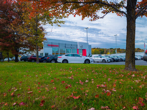 New Hartford, New York - Oct 6, 2022: Landscape Autumn View of Nissan Steet Ponte Dealership Building Exterior with Brand New Cars Parked in Front.