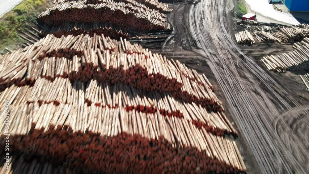 Poster dolly forward zoom drone shot tilted down to log piles in the background in a desert environment wit