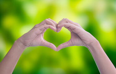 Hands making heart shape planting trees  the green bokeh background, loving the...