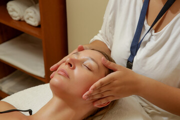 Obraz na płótnie Canvas Face massage, a woman in the spa having anti-age face massage