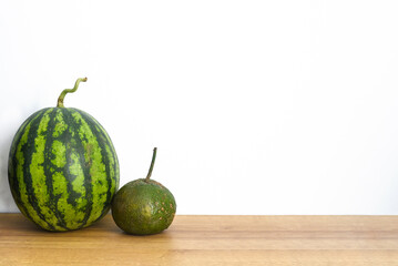 Watermelon and citrus fruits on a wooden table against white background