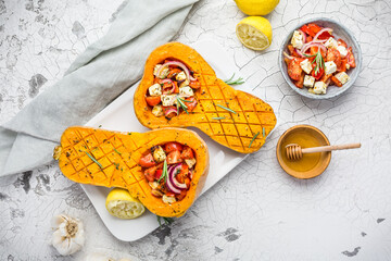 Halved roasted butternut squash with spicy vegetable filling and feta cheese