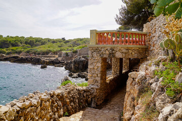 arch of a private property on the paved path along the coast at the edge of the walls of the luxury...